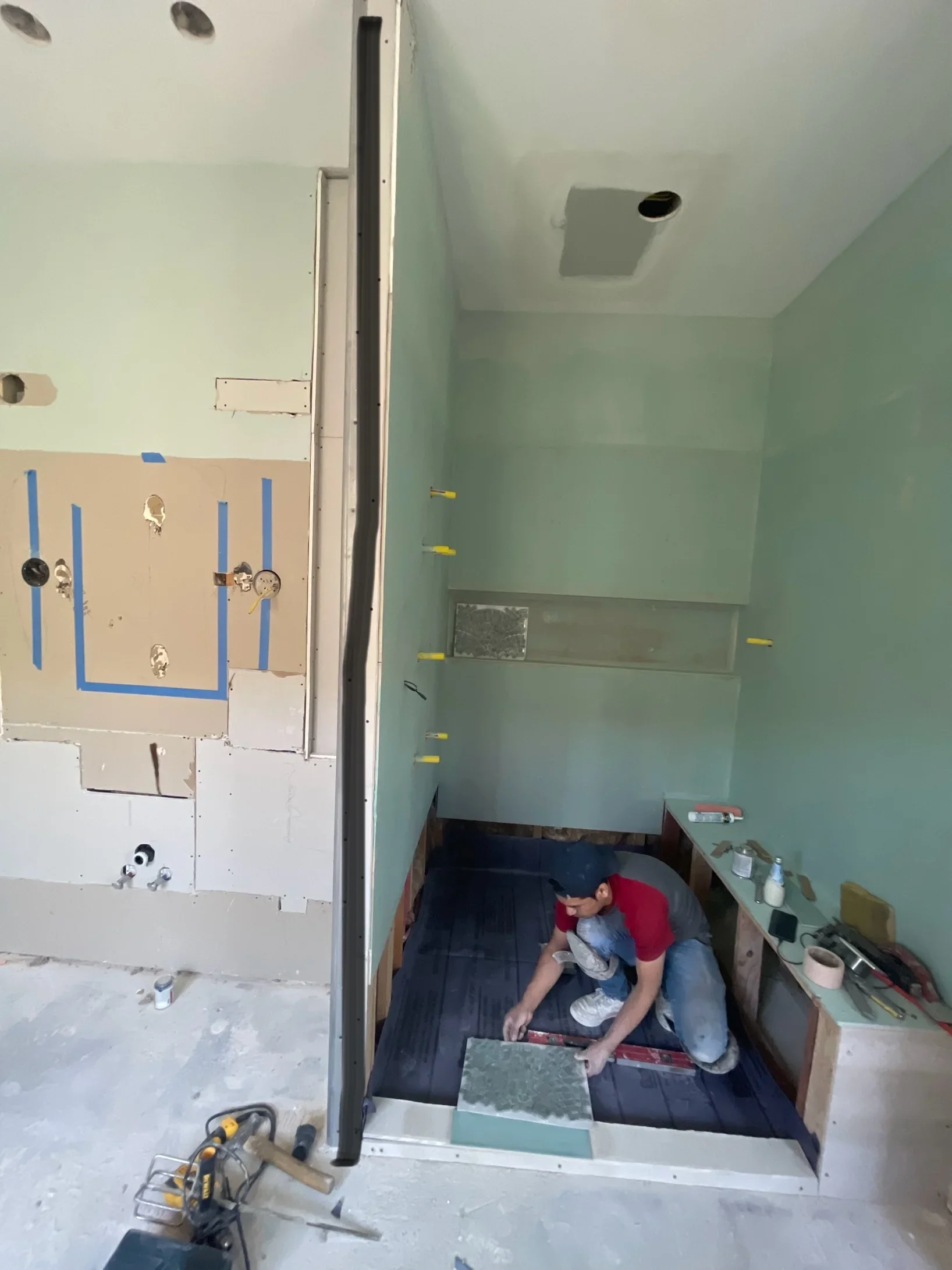 Bathroom renovation in progress with drywall installation, electrical rough-in, and fixture blocking